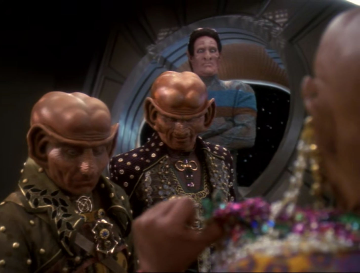 Lumba (girl Quark) flashing her titties at two other Ferengi dudes and their... manservant, who does not look impressed.